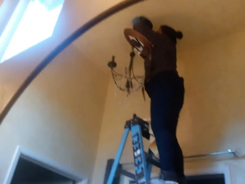 Electrician installing a chandelier in a Hastings residence